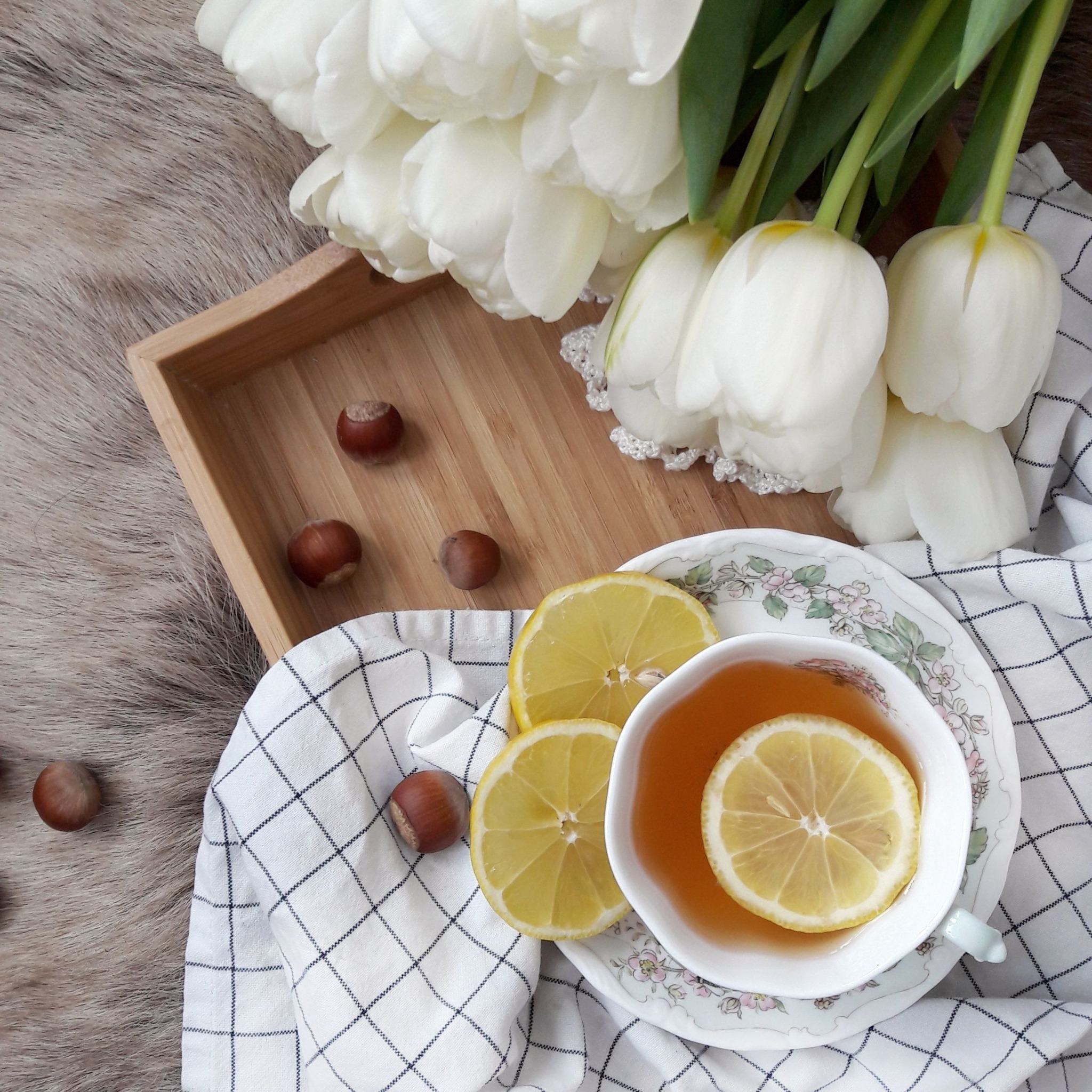 Tasse Tee mit Zitrone und weißen Blüten